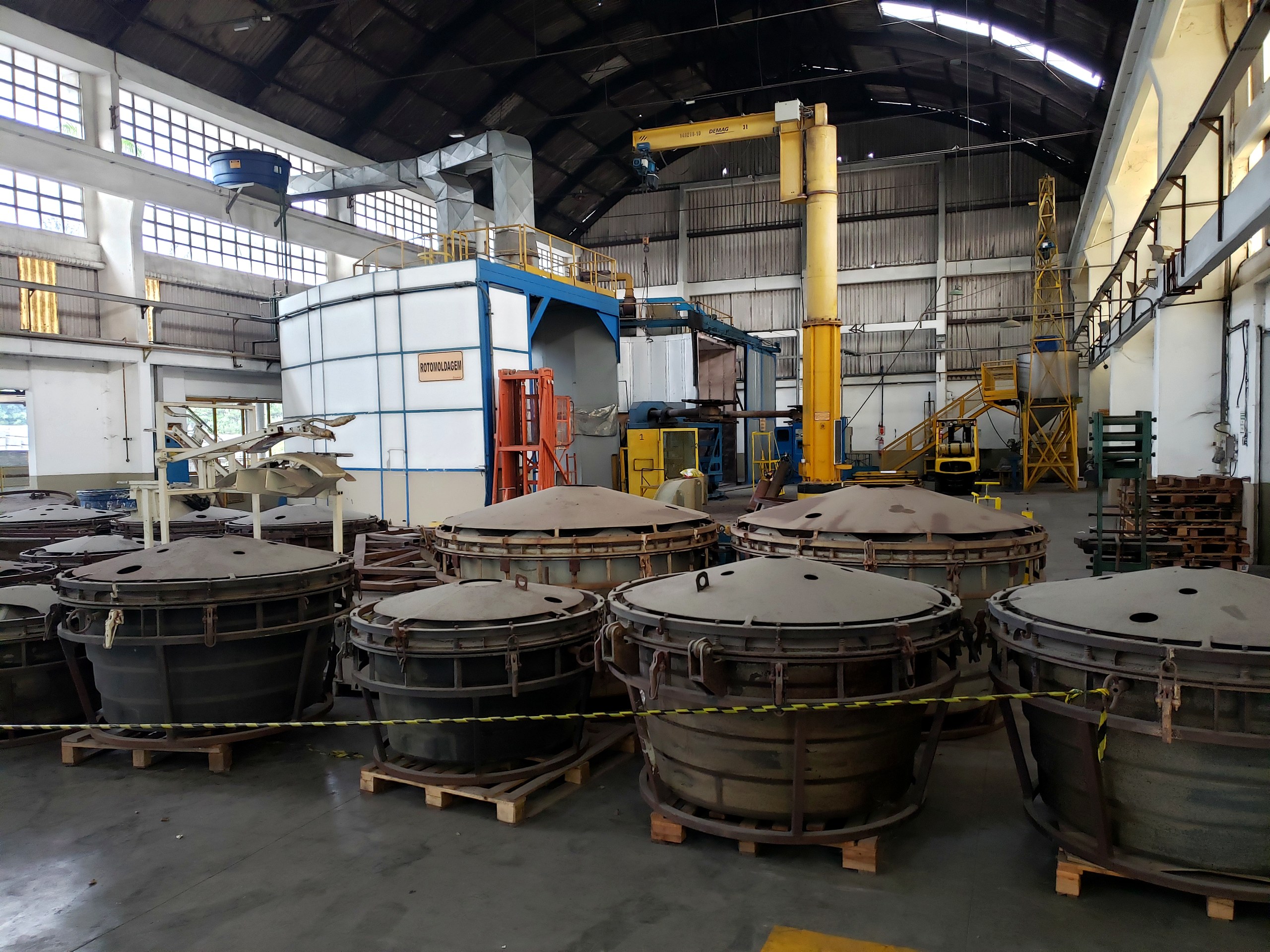 Tanques industriais metálicos sobre paletes em galpão de fabricação da Token Engenharia