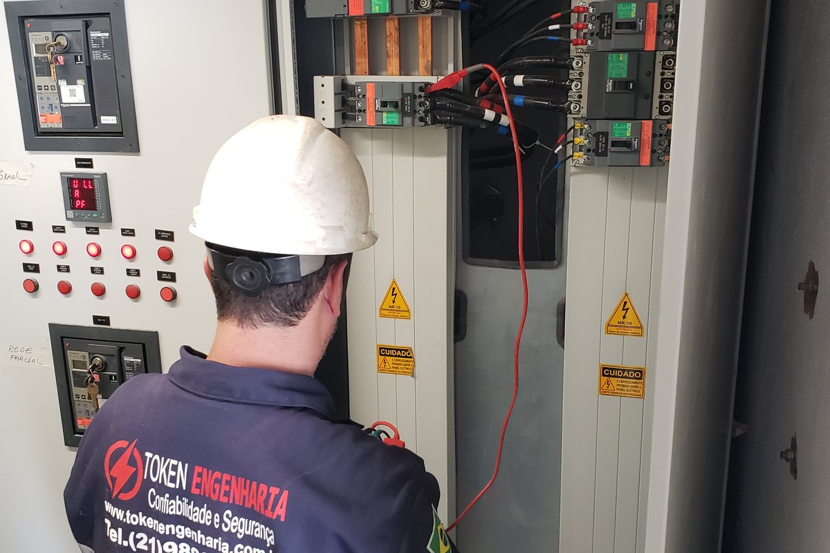 Técnico da Token executando ensaio de isolamento em quadro elétrico no comissionamento