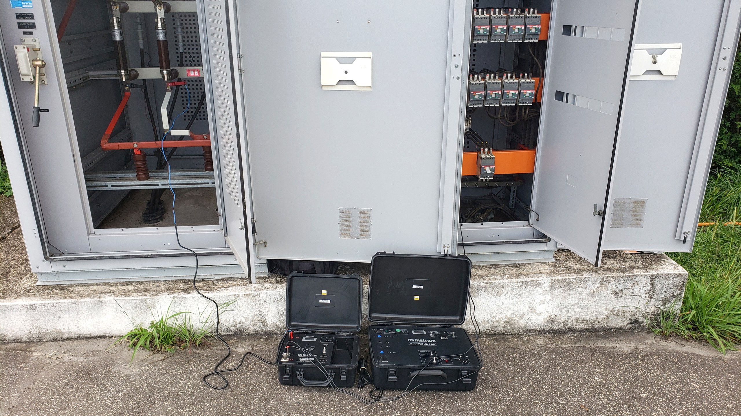 Cubículos de subestação abertos com instrumentos de ensaio durante comissionamento conduzido pela Token Engenharia
