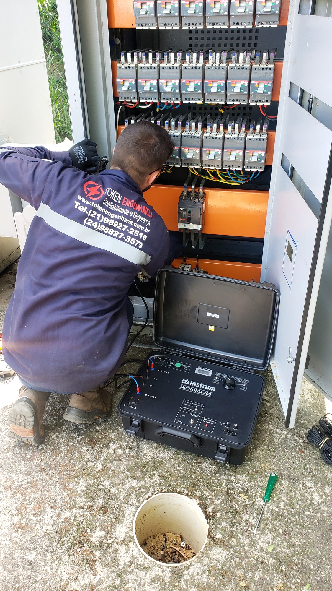 Técnico da Token Engenharia realizando ensaio de medição em quadro geral de baixa tensão durante serviço de conexão elétrica