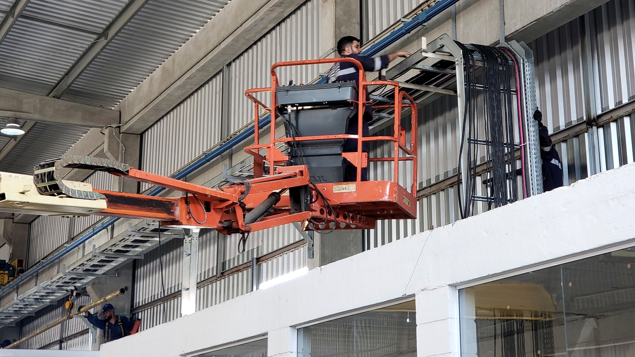 Equipe Token montando eletrocalha e cabeamento na estrutura de um galpão industrial