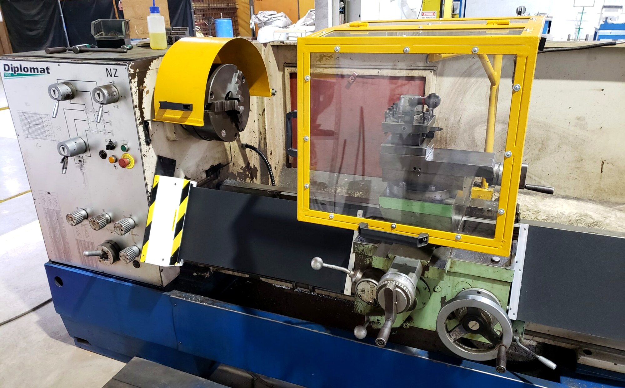 Torno mecânico industrial com proteção fixa, proteção móvel com intertravamento e botão de emergência avaliado em laudo NR-12 pela Token Engenharia