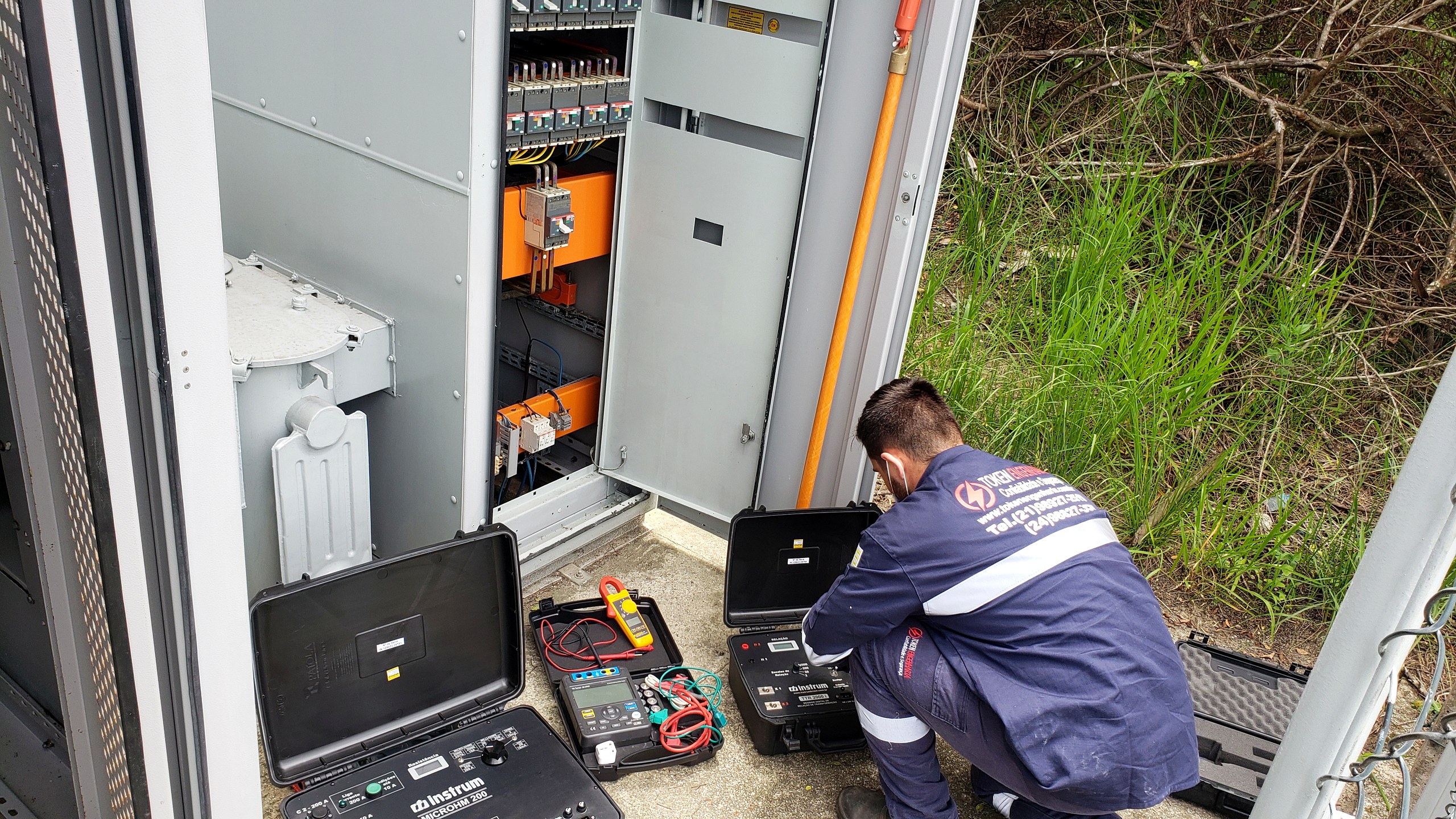 Técnico da Token Engenharia realizando ensaios e medições com instrumentos em um painel elétrico durante manutenção preditiva