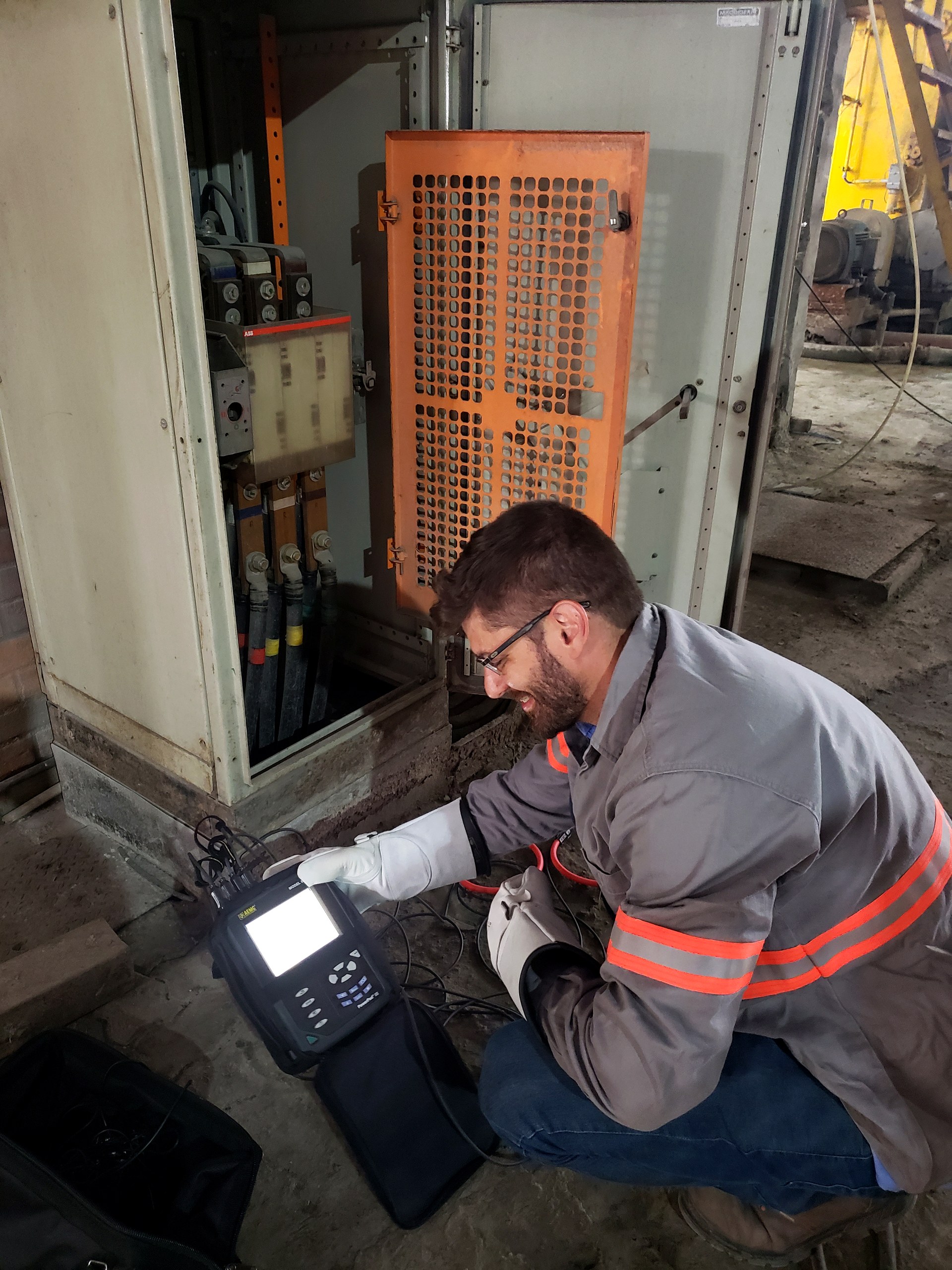 Técnico da Token Engenharia medindo qualidade de energia com analisador no quadro geral de baixa tensão
