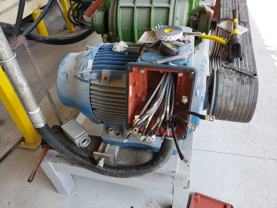 Detalhe de motor elétrico com caixa de ligação aberta e cabos terminados