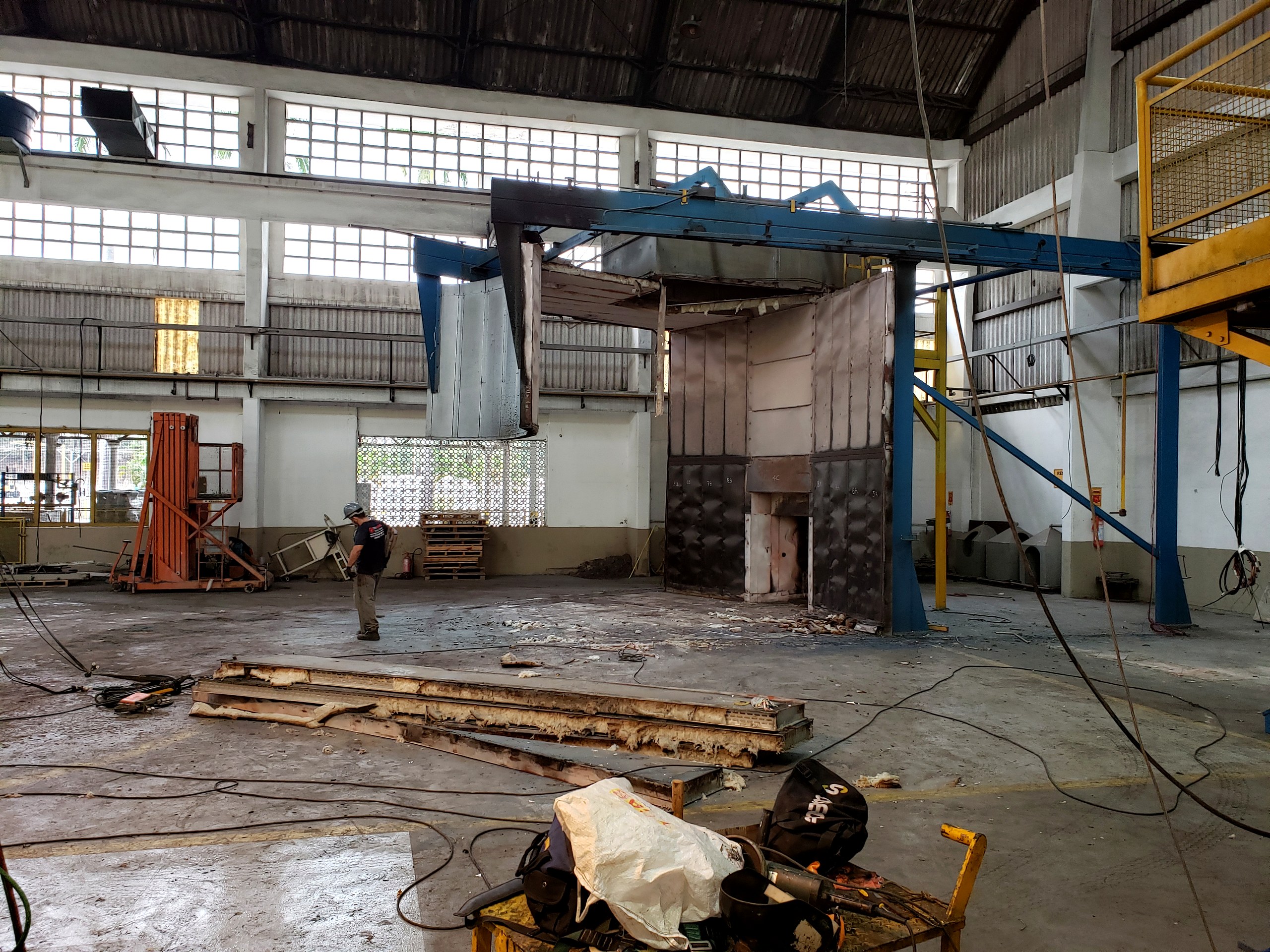 Montagem de estrutura metálica industrial com pórtico e vigas em galpão durante a obra
