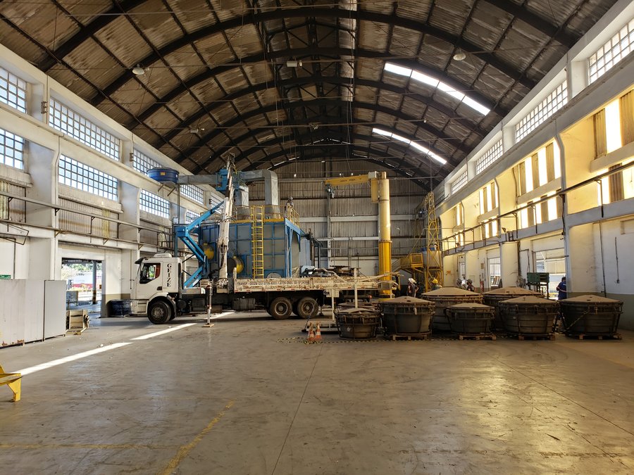 Galpão industrial com equipamentos de grande porte durante serviço de montagem