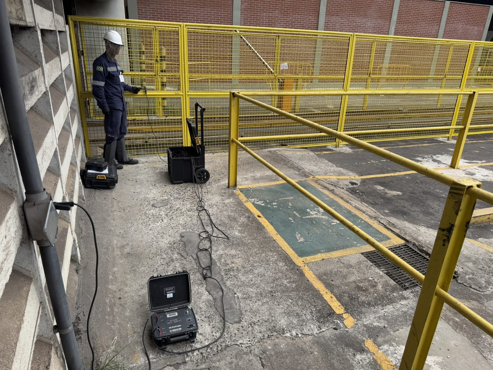 Técnico da Token Engenharia em ensaio de continuidade elétrica do SPDA com micro-ohmímetro digital, em área industrial