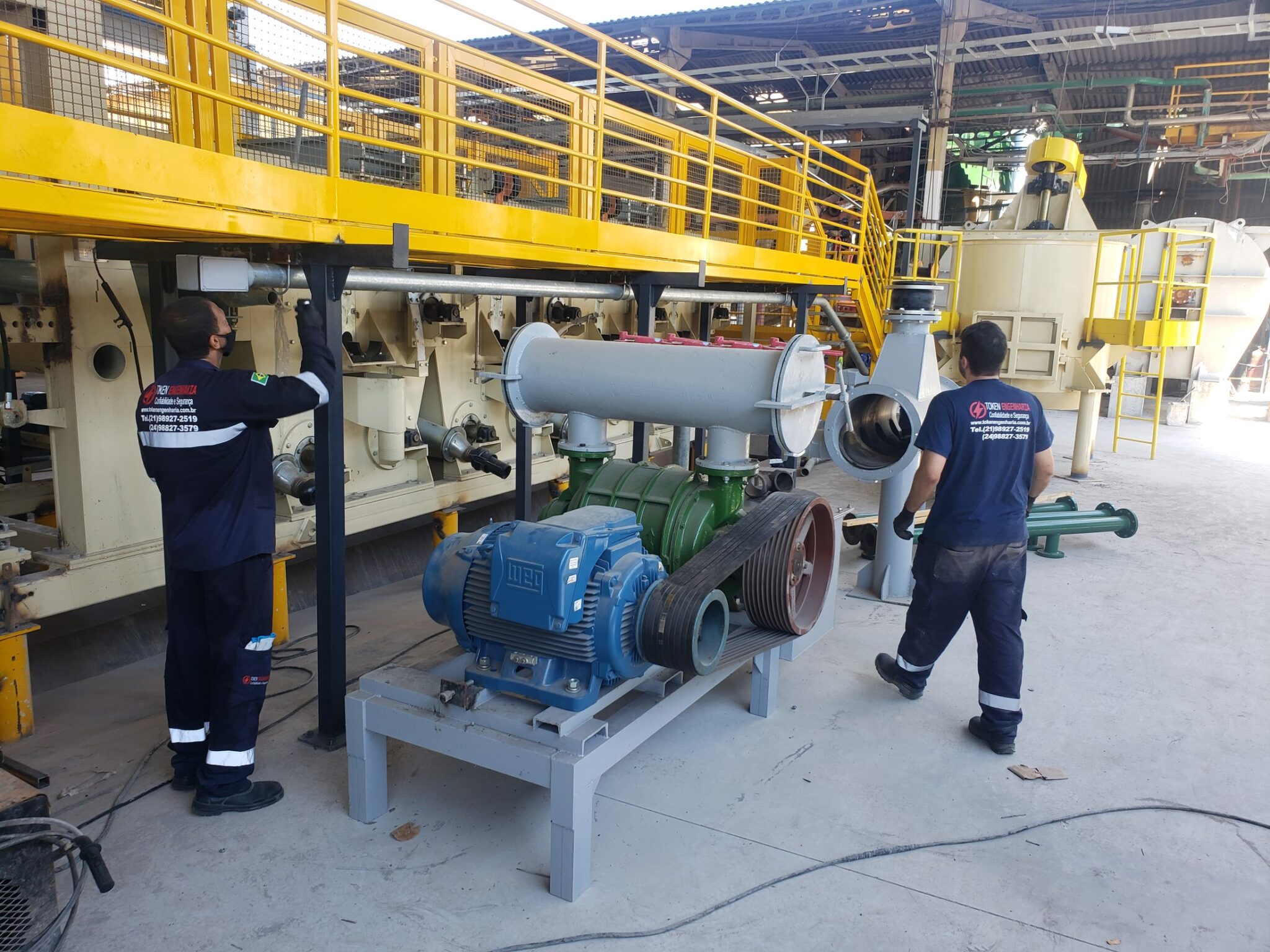 Técnicos Token em montagem de conjunto motor-bomba e tubulação industrial